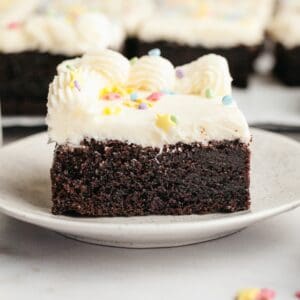 A slice of moist chocolate sheet cake with vanilla buttercream.