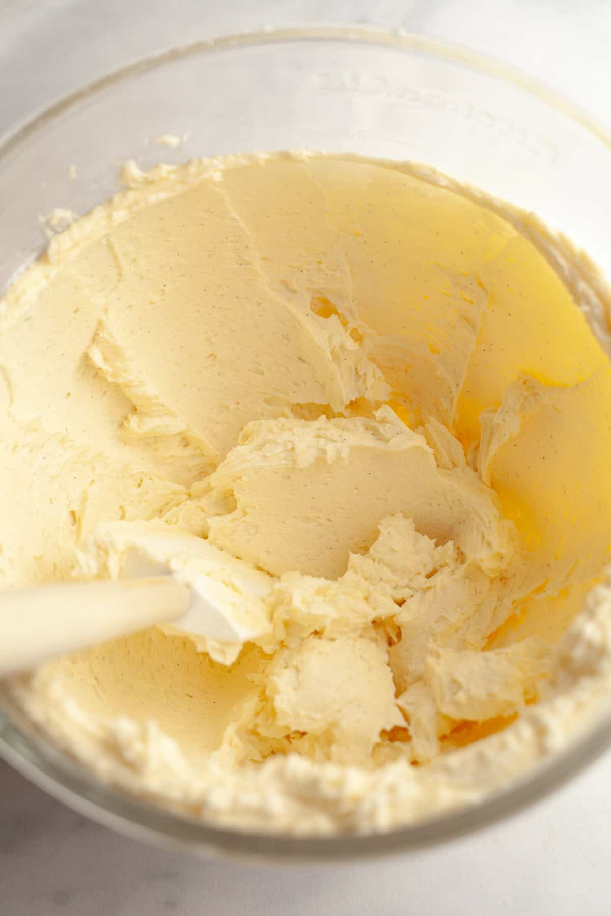Vanilla bean buttercream in a large glass mixing bowl.