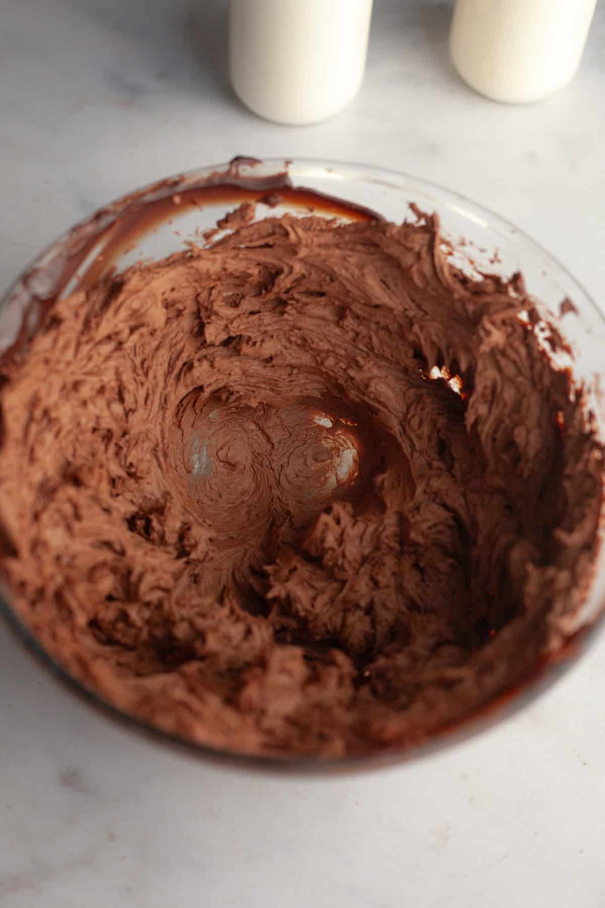 Whipped chocolate ganache in a glass bowl.