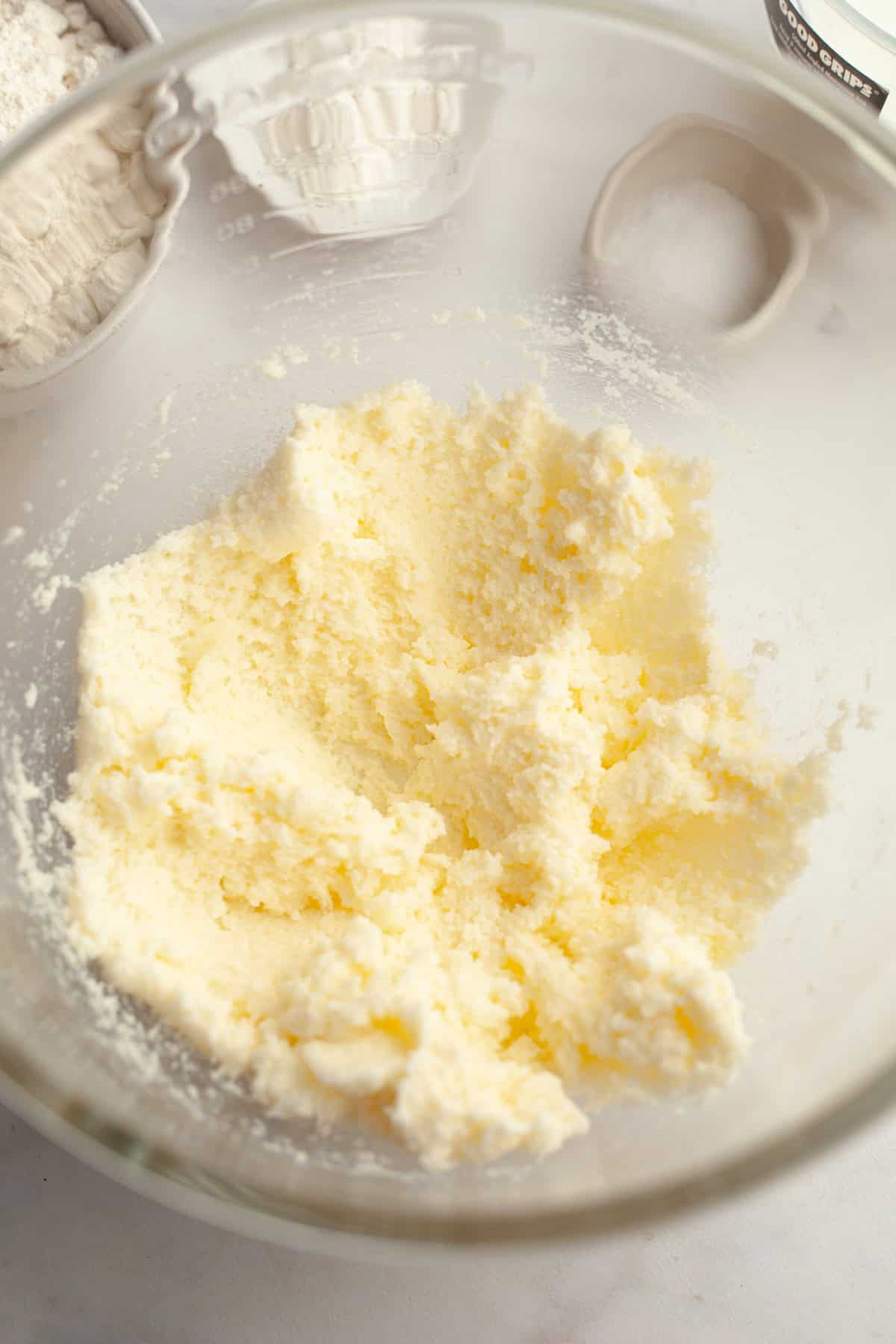 Creamed butter, sugar, and oil in a glass bowl.