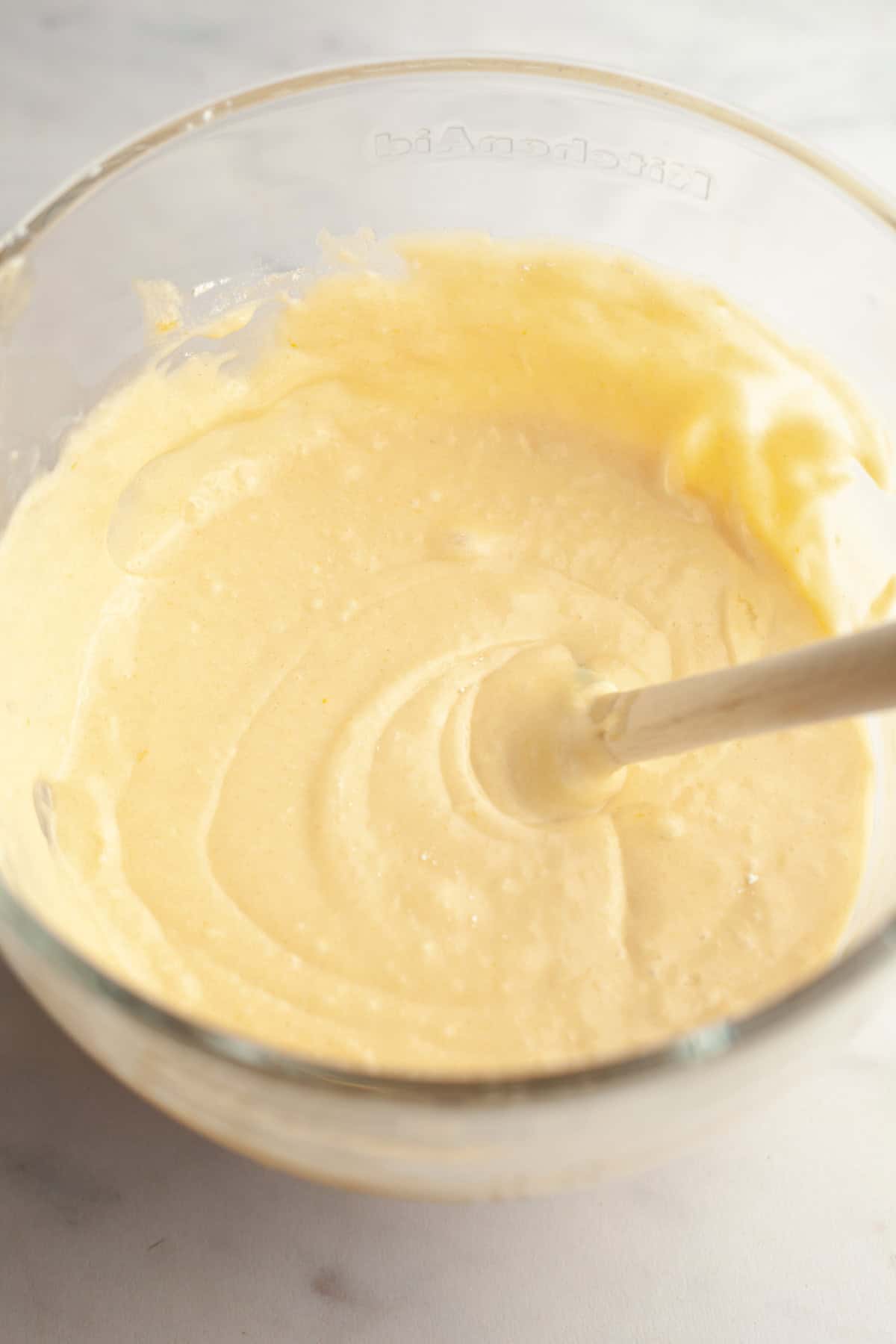 Yellow cake batter in a glass bowl.