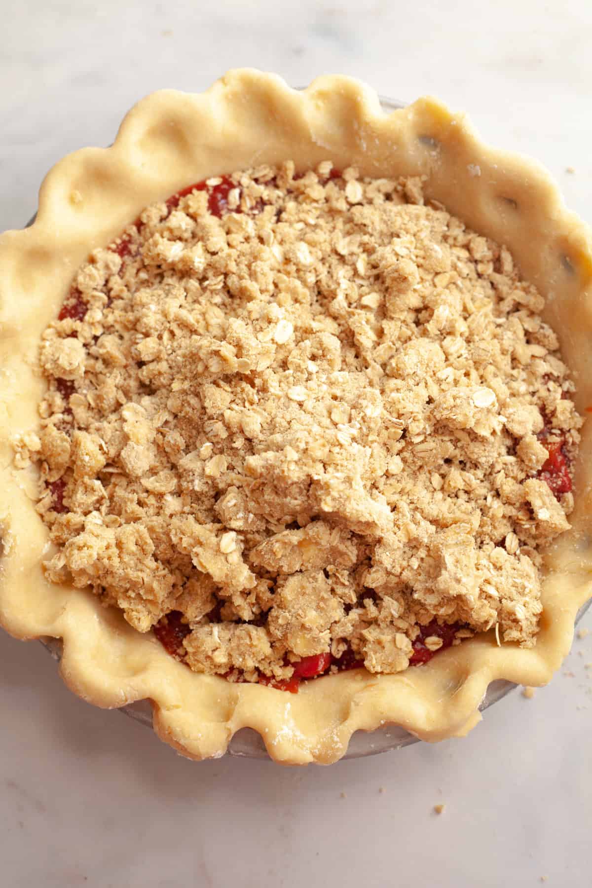 Unbaked strawberry rhubarb crumble pie.