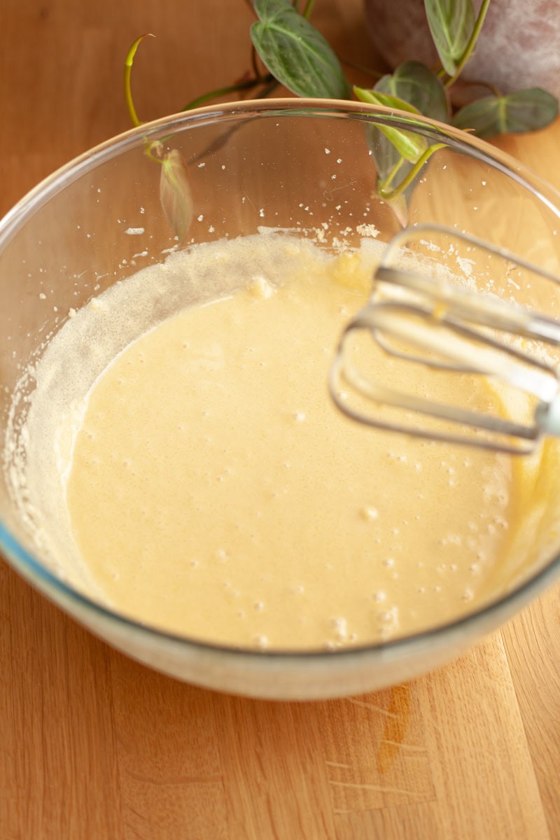 A glass bowl with cake batter in it.