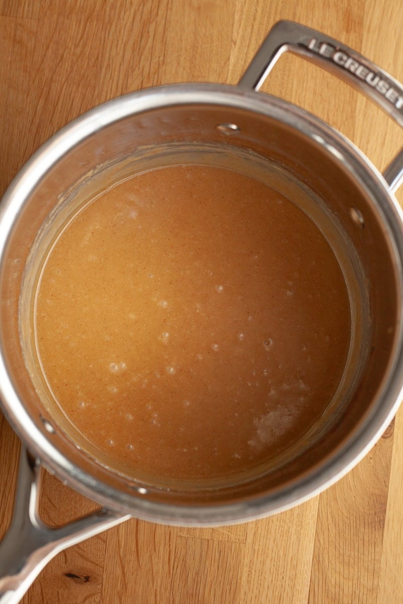 A silver saucepan with a light brown mixture in it.