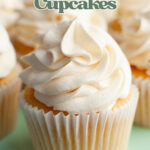 A yellow cupcake with white frosting on a teal cake stand.