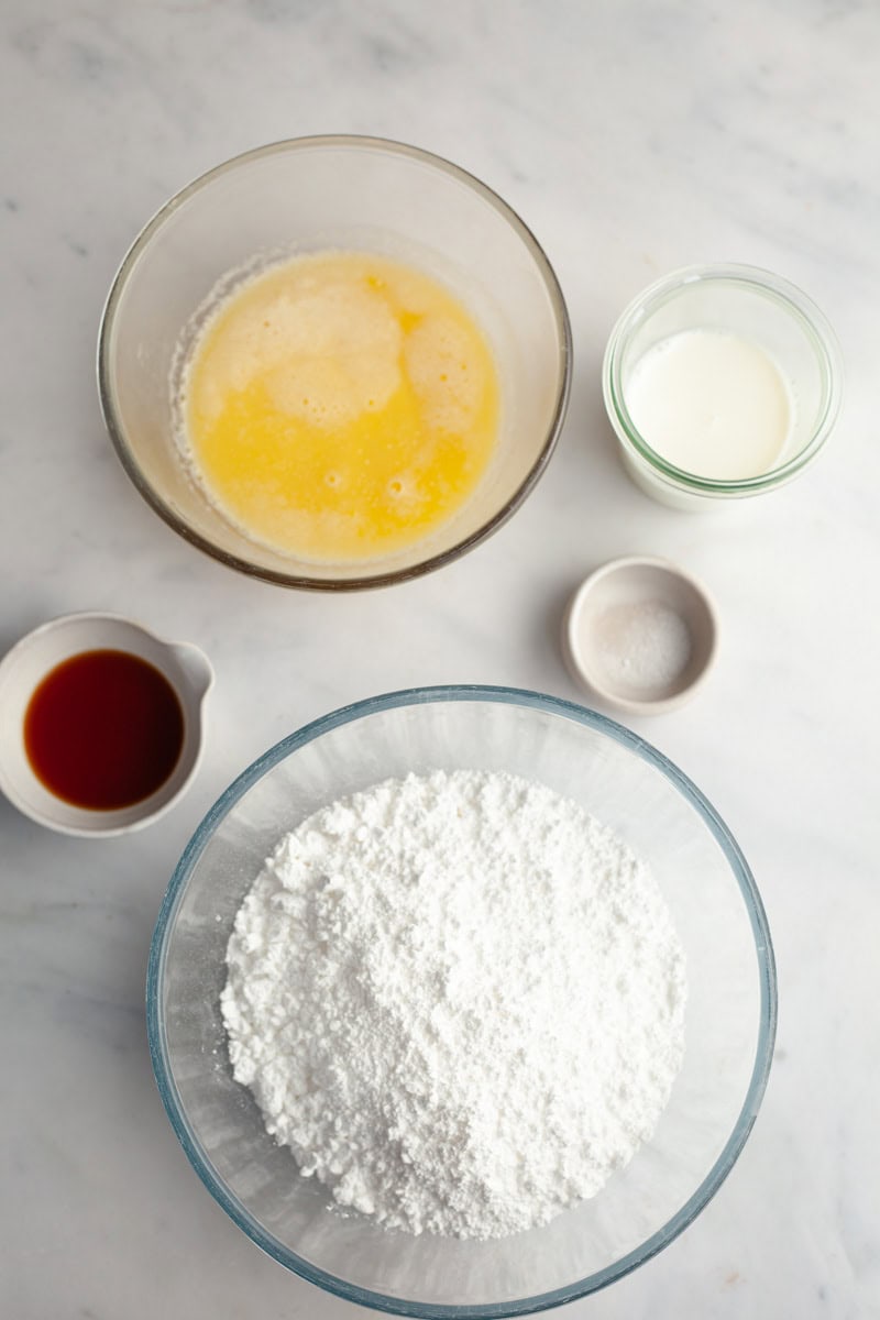Ingredients needed to make browned butter frosting, weighed out into small bowls.