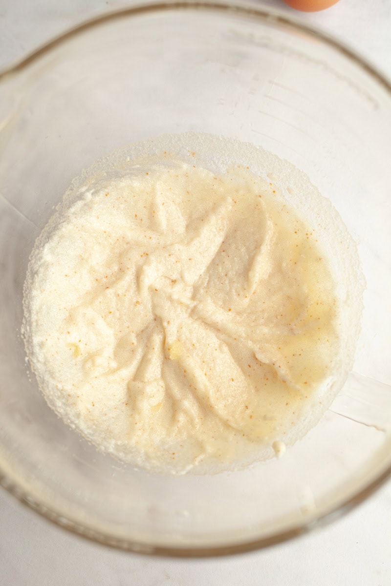Brown butter cake batter in a glass mixing bowl.