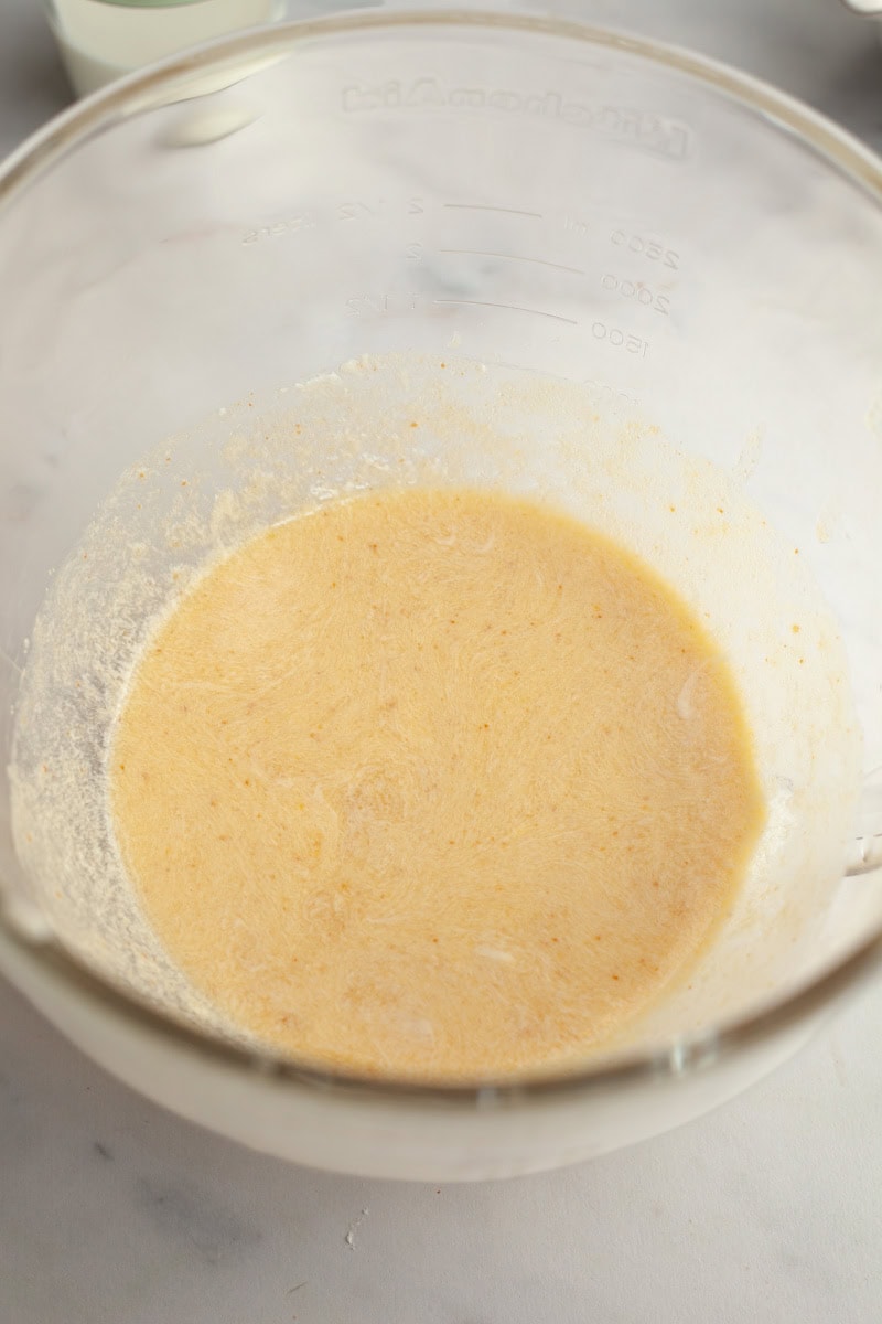 Brown butter cake batter in a glass mixing bowl.