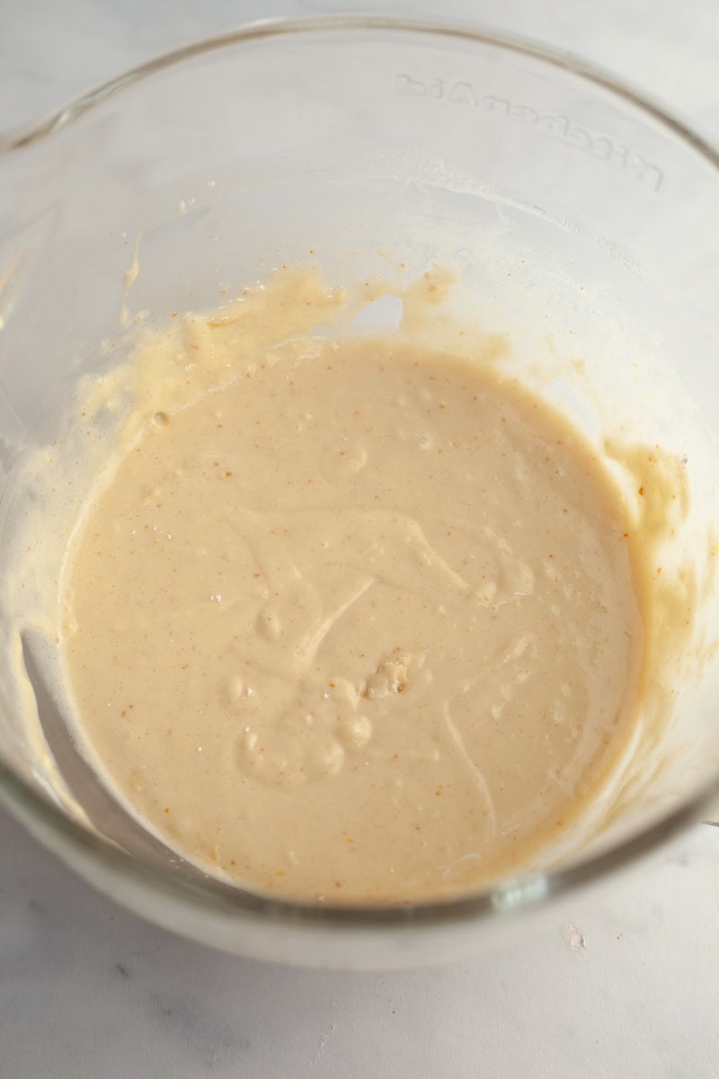 Brown butter cake batter in a glass mixing bowl.
