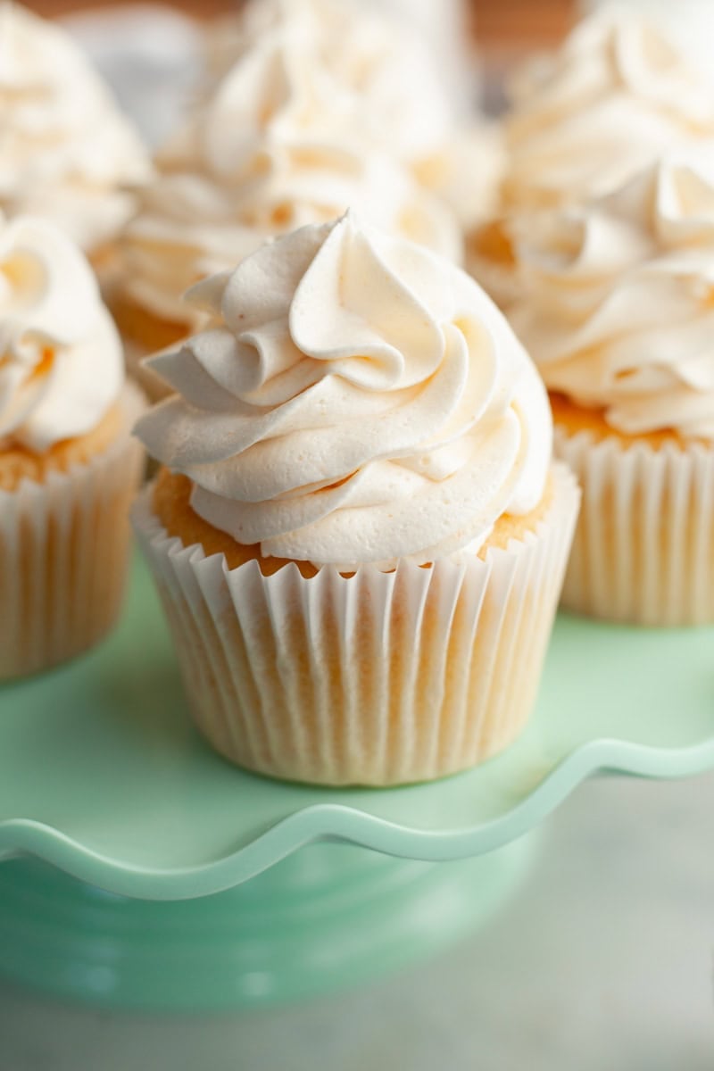 Browned butter cupcakes on a turquoise cake stand.
