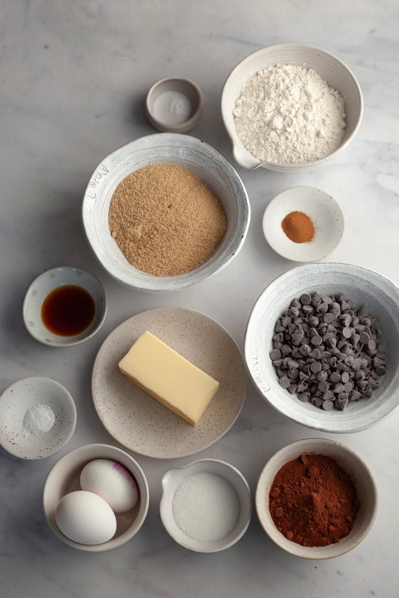 All the ingredients needed to make dark chocolate cookies, weighed out into small bowls.