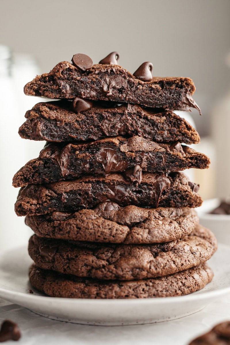 A stack of double chocolate cookies, cut in half so you see melting chocolate chips inside.