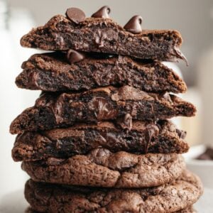 A stack of double chocolate cookies, cut in half so you see melting chocolate chips inside.